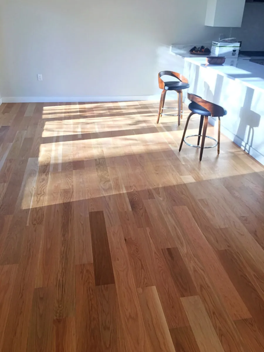 Newly installed oak floor running through an open kitchen